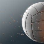A dirty white volleyball caught in slow motion flying through the air scattering sand particles in its wake - 3D render